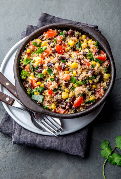istock Mexican black bean corn quinoa salad in clay bowl top view, copy space 1161511308