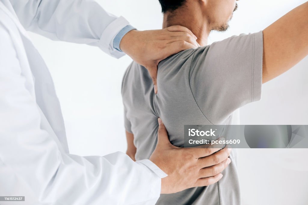 理学療��法士は、男性の背中に癒しの治療を行います。腰痛患者、治療、医師、マッサージセラピスト.オフィス症候群 - 肩のロイヤリティフリーストックフォト