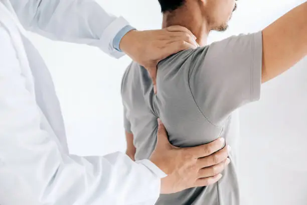 Photo of Physiotherapist doing healing treatment on man's back.Back pain patient, treatment, medical doctor, massage therapist.office syndrome