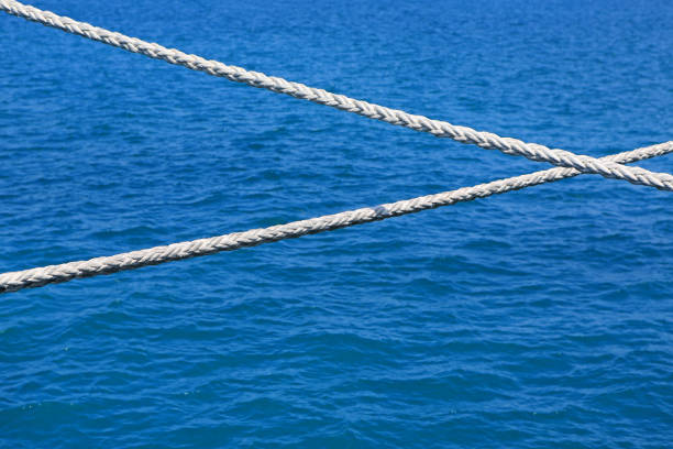 Ship rope against blue water sea texture background.