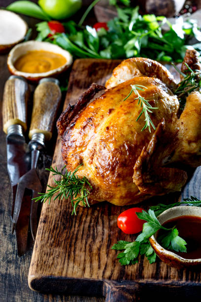 istock Baked whole chicken on wooden board. Close up 1161518159