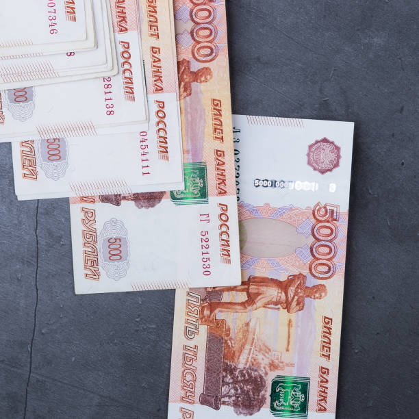 istock Big stack of Russian money banknotes of five thousand rubles lying on a grey cement background. 1161523877