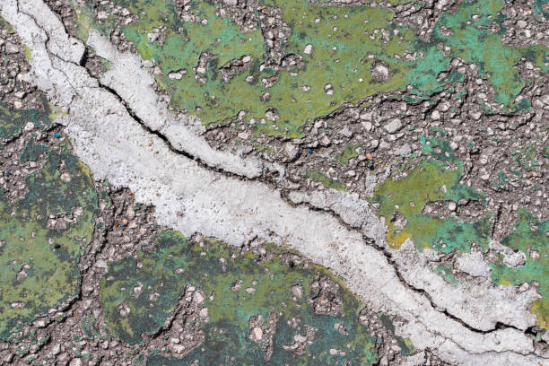 istock Concrete background in cracks of green color 1161527853