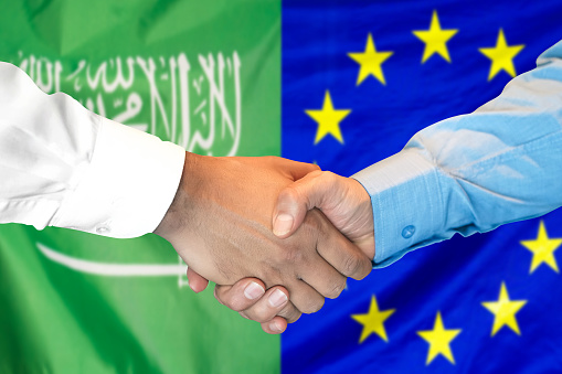 Business handshake on the background of two flags. Men handshake on the background of the Saudi Arabia and flag. Support concept