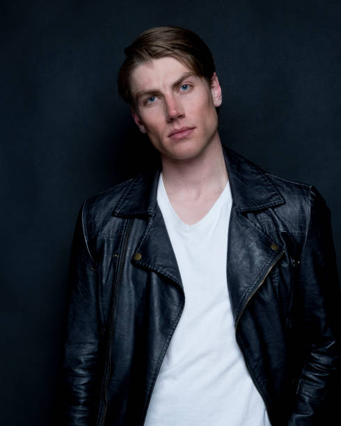 istock Handsome man wearing leather jacket and white tshirt on black background 1161531276