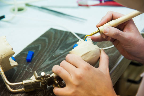 istock Dentist makes a dental implant prosthesis made of plaster cast 1161533710