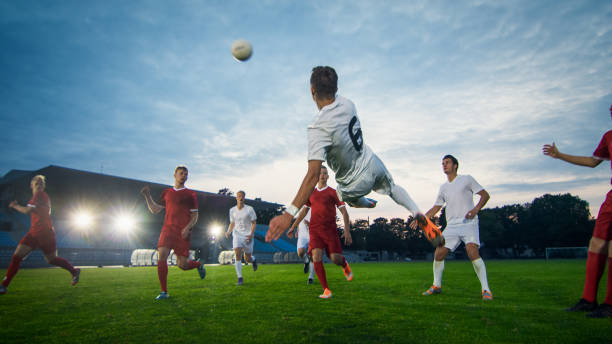 jugador de fútbol recibe pase exitoso y patadas bola para anotar increíble gol haciendo tiro de bicicleta. disparo hecho en un campeonato del estadio. - jugador de fútbol fotografías e imágenes de stock