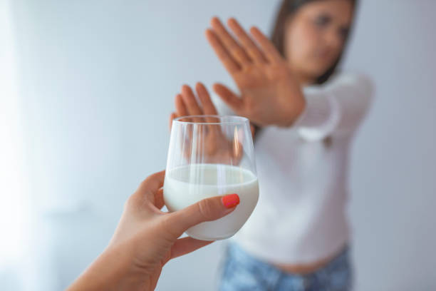 Lactose intolerance A woman feels bad, has an upset stomach, bloating due to lactose intolerance. Dairy intolerant person. Health care concept. Lactose intolerance and dairy products lactose fermentation stock pictures, royalty-free photos & images