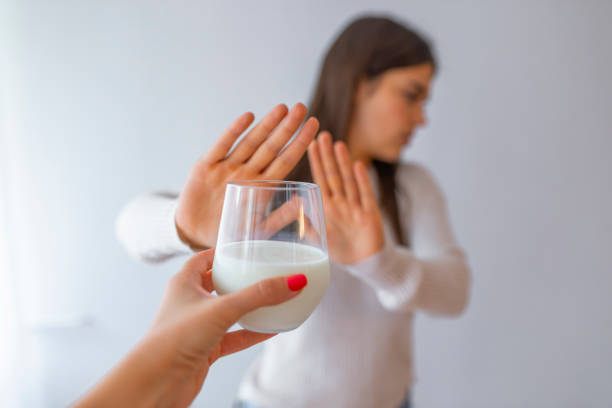 Lactose intolerance Lactose intolerance, health problem with dairy food products concept. Woman holding glass of milk having bad stomach ache. Young woman refusing to drink milk lactose fermentation stock pictures, royalty-free photos & images