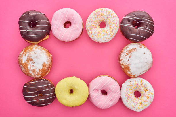 istock frame of delicious glazed doughnuts on bright pink background 1161540660