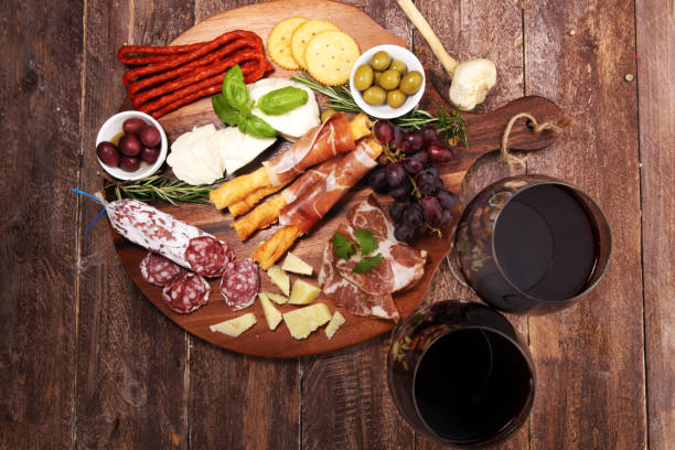 istock antipasto various appetizer. Cutting board with prosciutto, salami, cheese, bread and olives on dark wooden background 1161543223