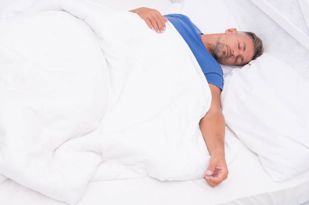 istock Healthy habits. Man handsome guy lay in bed sleeping. Get enough amount of sleep. Tips sleeping better. Bearded peaceful man sleeping face relaxing on pillow covered blanket. Total relaxation 1161543849