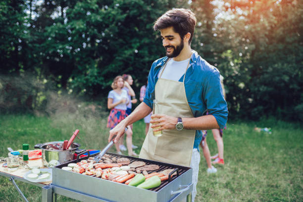 istock Handsome male preparing barbecue outdoors for friends 1161544254