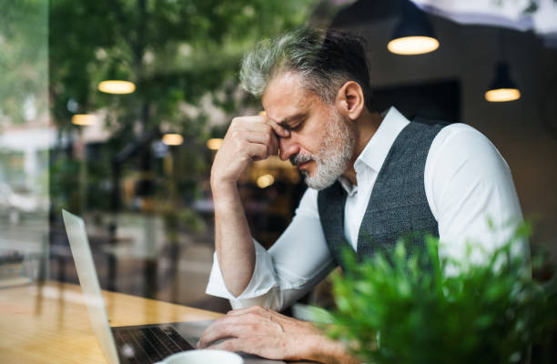 istock Frustrated mature man sitting at the table in a cafe, using laptop. 1161545213