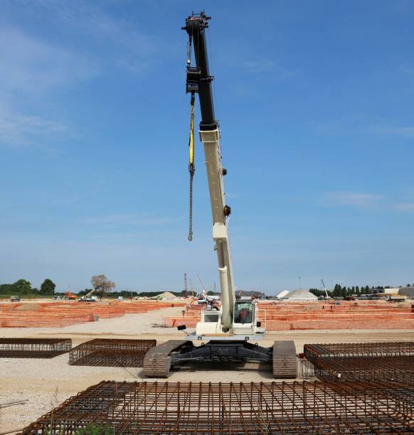 istock Tracked mobile telescopic crane in a large construction site,  with steel cages in front and building activity behind 1161546735