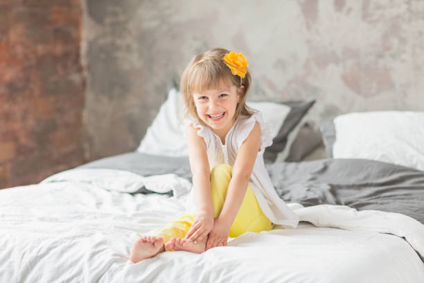 istock Happy child girl having fun on a bed 1161547827