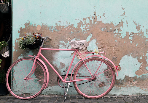 Pink vintage bike leaning against a weathered wall in Havana