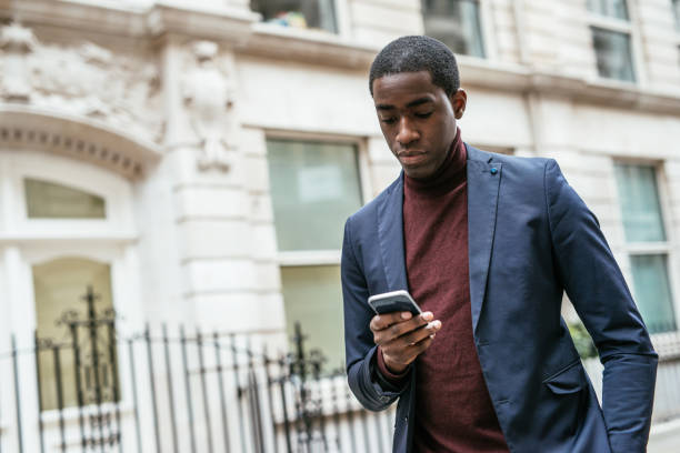 istock Mature African businessman in suit using smart phone 1161554021