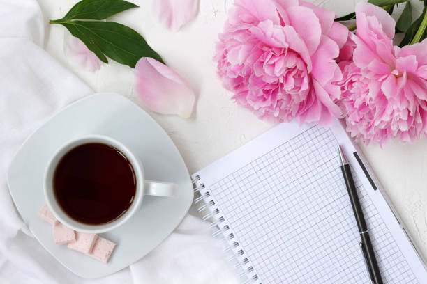 istock morning mood, cup of coffe, flowers and notepad on white textured table 1161555038