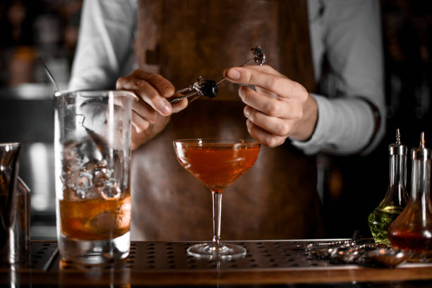 istock Male bartender putting berry on the skewer with tweezers 1161557280