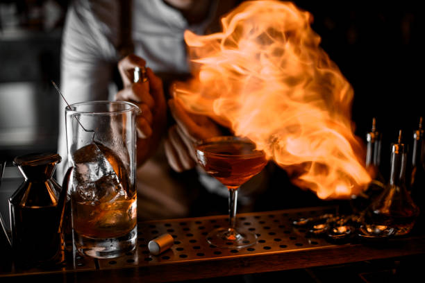 istock Male bartender putting fire from the lighter on the cocktail glass 1161557313