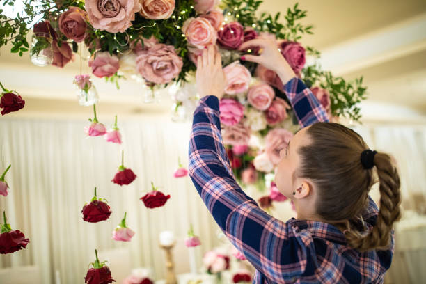 istock Woman arranging floral wedding decor in restaurant 1161558456