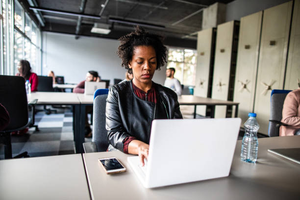 istock Attractive African woman using laptop in the office 1161559673