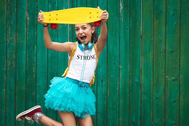istock Happy and fun beautiful girl jumping with skateboard 1161559991