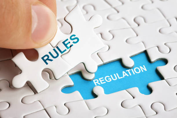 istock White puzzle with word RULES and REGULATIONS. 1161560159