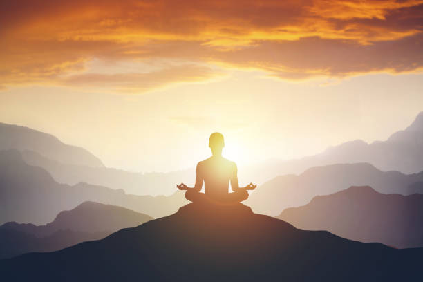 silueta del hombre de meditación en la montaña - meditation fotografías e imágenes de stock