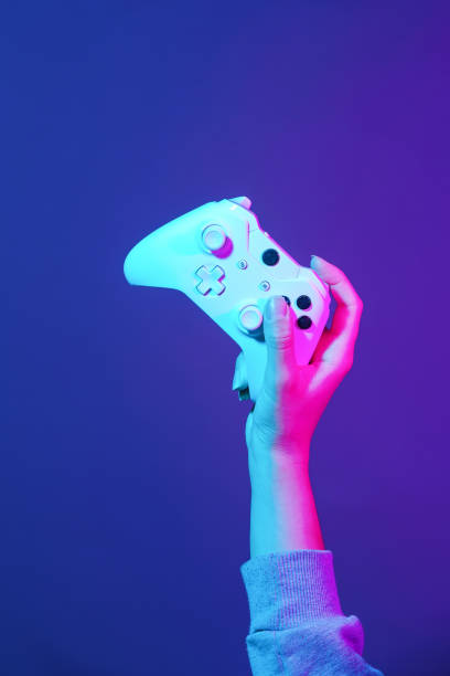 istock Hand with white gamepad on dark violet background. 1161562114