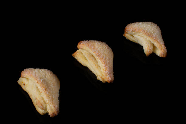 istock Cookies from a puff pastry triangle on a black background 1161564819