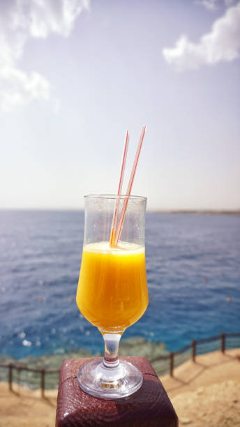 istock glass of fresh mango on the table on sea background 1161564935