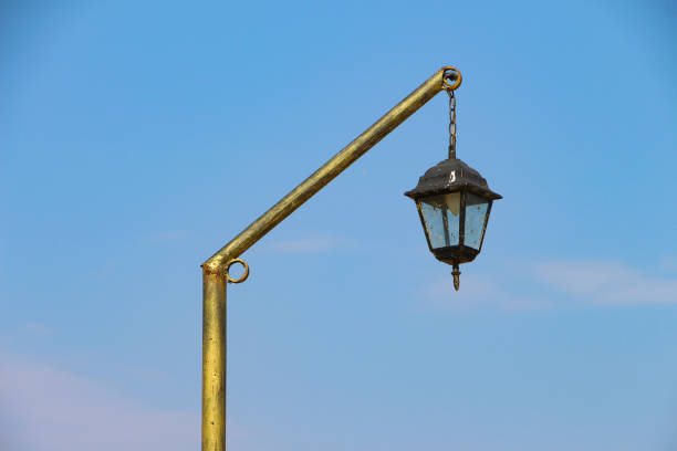 Gilded old vintage street lantern isolated on blue sky horizontally