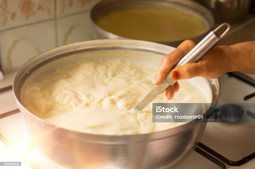 Hands of senior woman who is making yogurt Hands of senior woman who is making homemade yogurt ( yogurt ) with selective focus. Fermentation of yoghurt with blurred background. Yogurt Stock Photo