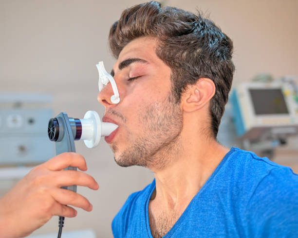 istock Doctor reviews patient's lung capacity with a peak flow meter 1161568440