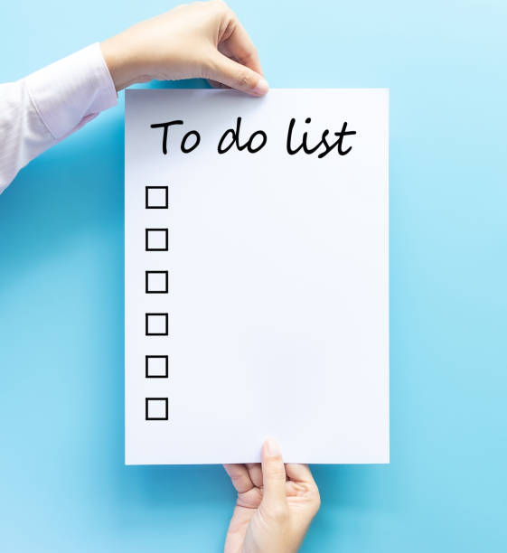 hand holding paper with to do list and checkbox by hand drawn text isolated on blue background, planning and design concept