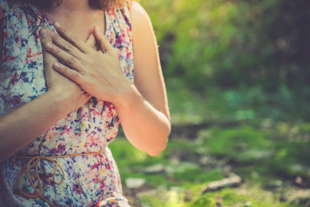 녹색 숲에서 명상의 닫기 - spirituality hand on heart meditating women 뉴스 사진 이미지