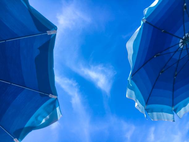 Cielo e ombrelloni blu sulla spiaggia - foto stock