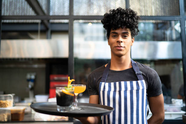 istock Portrait of young waiter holding a serving tray with drinks 1161574837