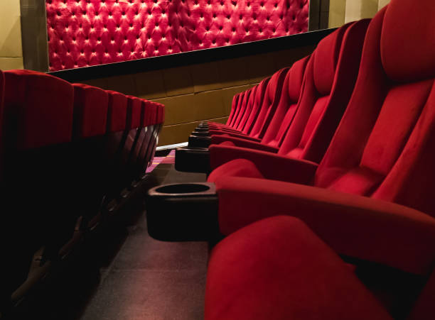 Empty red cinema seats in movie theatre auditorium ready for film premiere audience stock photo