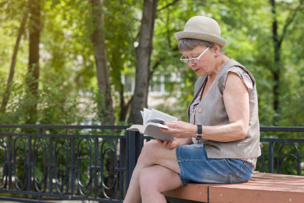 istock An elderly woman reading a book outdoors. 1161577749