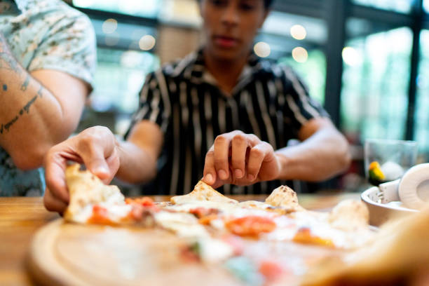 istock Close-up of young man taking a pizza slice 1161578513