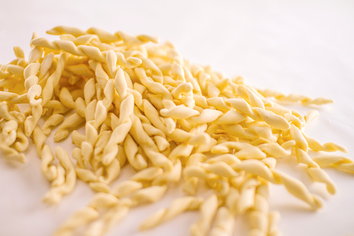 Close up still life of italian handmade pasta fusilli al ferretto on white background