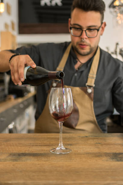istock Waiter offering cup of wine in a pub 1161580050