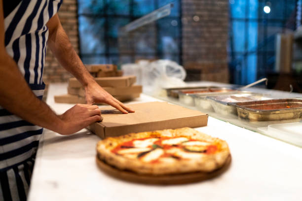 dostawca pizzy przygotowuje zamówienie, aby przejść - pizza one person service human hand zdjęcia i obrazy z banku zdjęć
