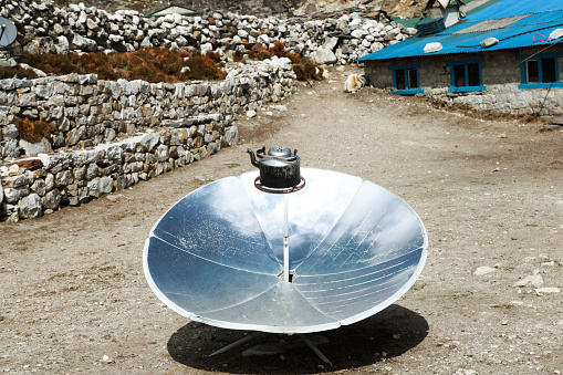 Warming the teapot in a solar cooker. Ecology concept. Renewable green energy. Nepal. Himalaya.