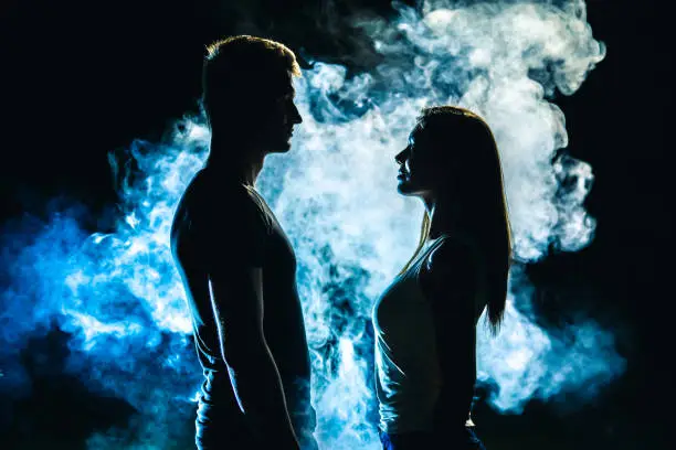Photo of The couple standing in smoke on the dark background