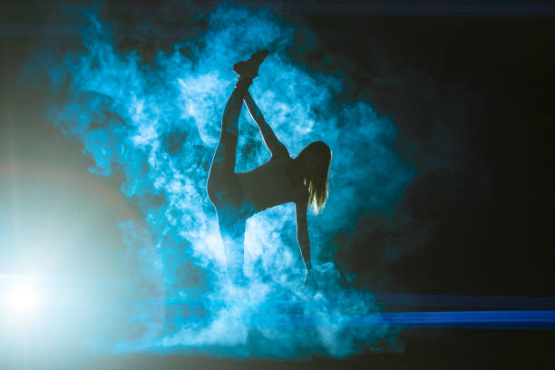 istock The woman doing vertical split in the smoke on the bright light background 1161583931