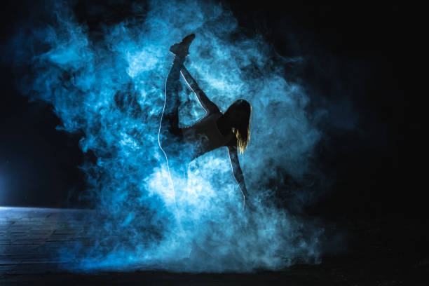 istock The gymnast doing vertical split in the smoke on the dark background 1161584395